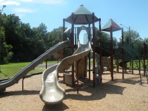 A large playground with benches sits at the back of the park